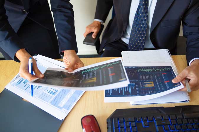 investor-trader-discussing-statistic-data-holding-papers-with-financial-charts-pen-cropped-shot-broker-job-trading-concept