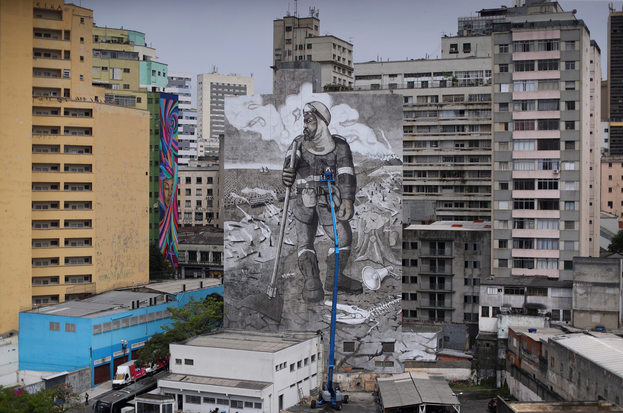 Brazilian artist and activist Mundano works on the mural 'The Forest Brigade' using paint made with ashes collected and brought from fires in Amazon, Pantanal and other biomes, in Sao Paulo