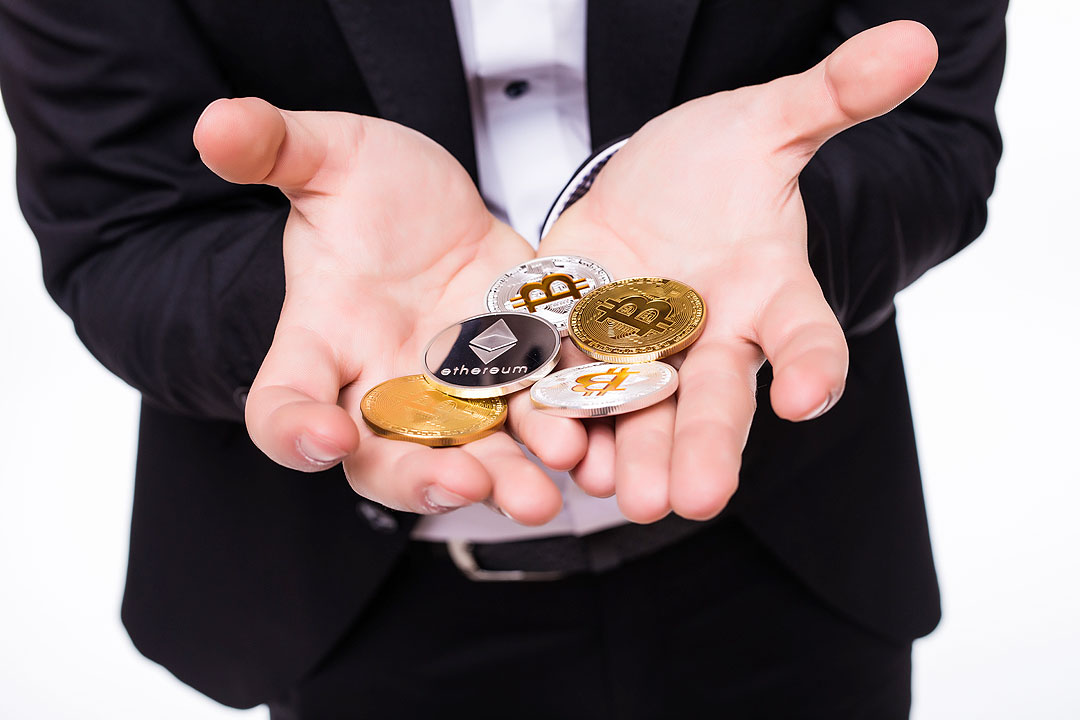 man-holds-different-crypto-coins