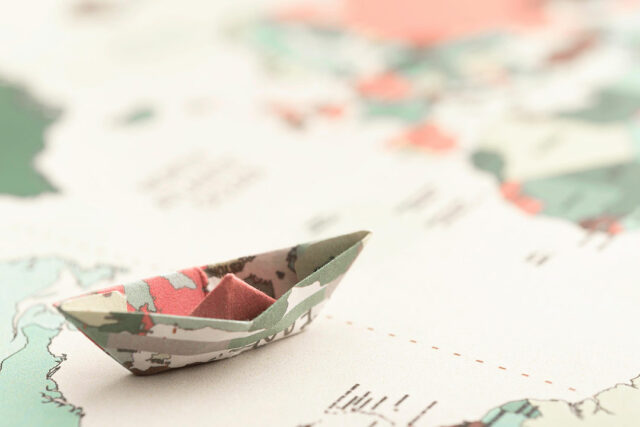 high-angle-small-origami-boat-world-map