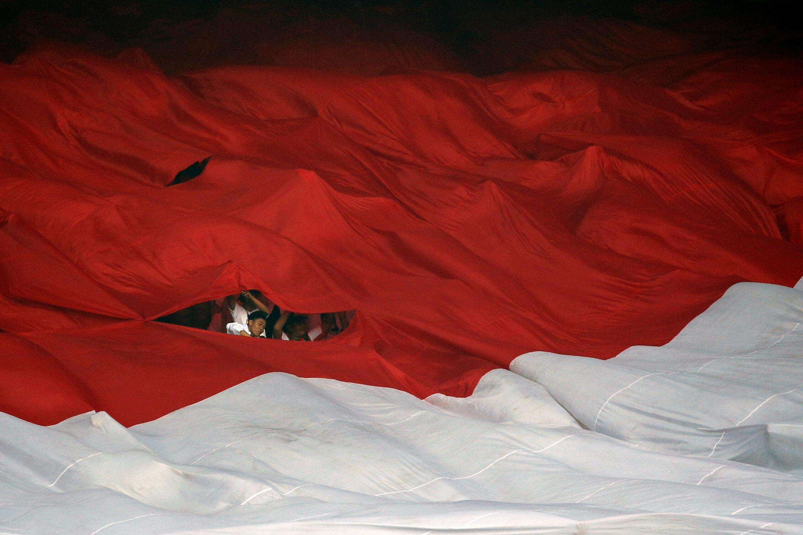 Man is seen behind an Indonesia's national flag during a campaign rally of Indonesia's presidential candidate Prabowo Subianto and his running mate Sandiaga Uno at Gelora Bung Karno Main Stadium in Jakarta