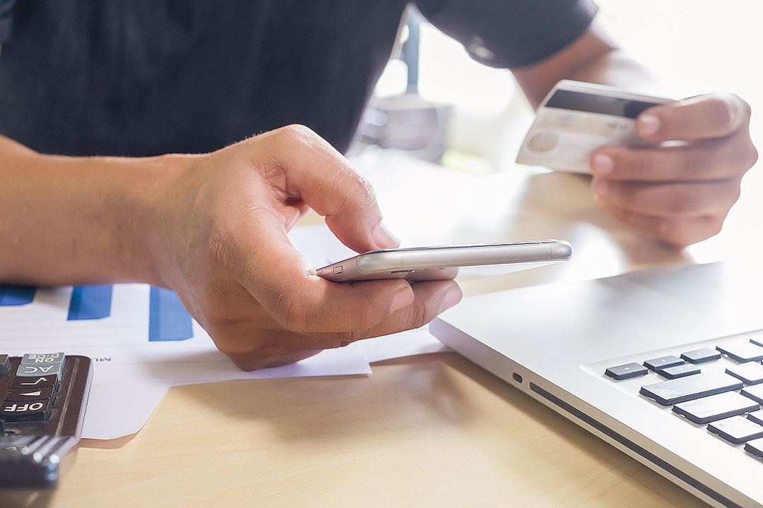man-holding-mobile-phone-credit-card-laptop-online-shopping
