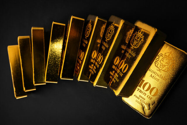 Gold bars stacked on a dark surface