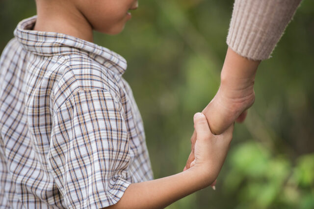 close-up-happy-mum-son-holding-hand-park-family-concept